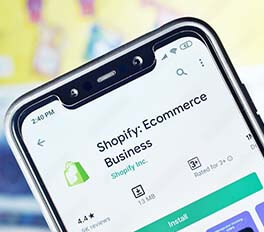 mobile device screen that says 'Shopify Ecommerce Business' on the screen