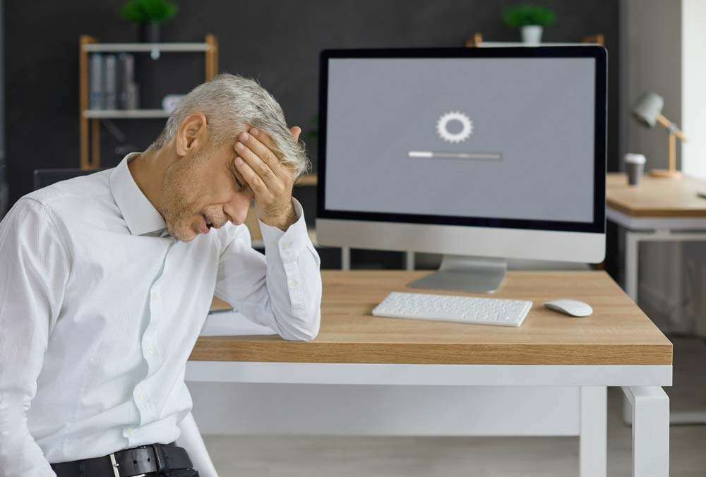 a man holding his head down in frustration of his slow loading website